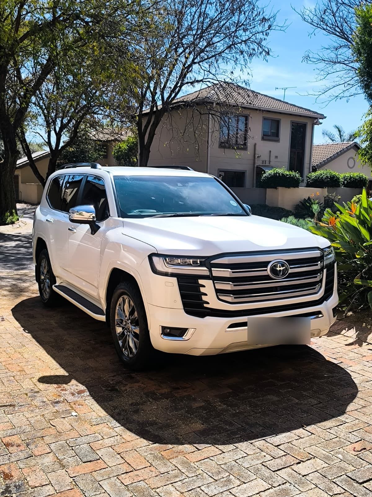 Toyota Land Cruiser 300 in white, finished and dry on a paved driveway after a full exterior detail